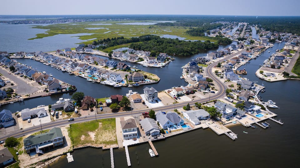 A coastal town with a marina, houses, and a river.