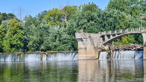 Maumee River Dam Fort Wayne, IN panorama on bright and sunny summer day with logs over waterfalls