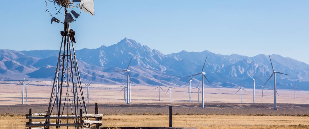 Old broken wind mill in front of big new wind farm in the Minera