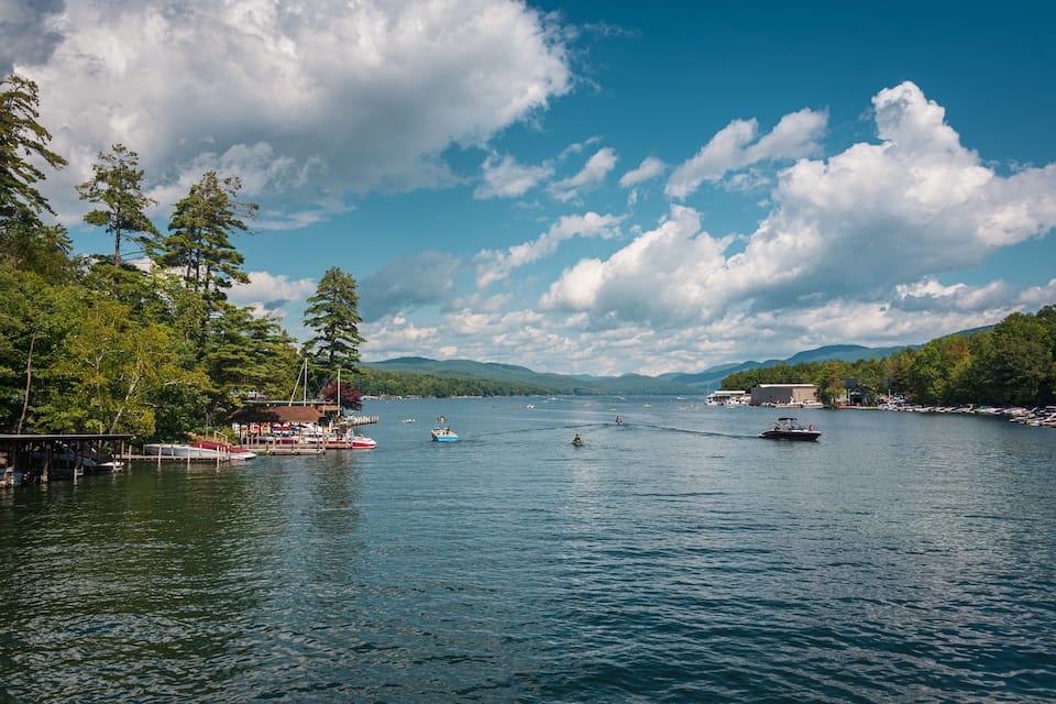 A lake with boats, docks, and trees.