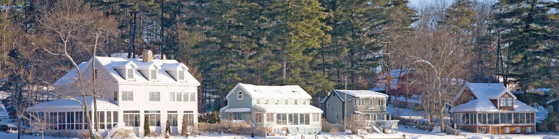 Houses on frozen pond with snow, Stow, Ma., New England, USA