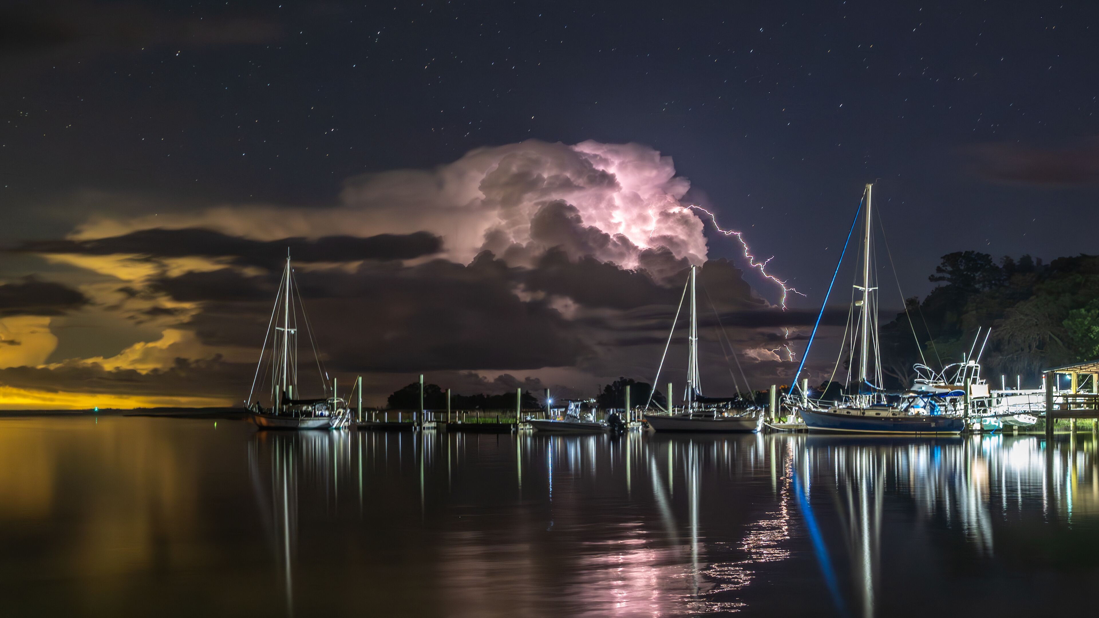 Lightning bursting out from cloud with coastal landscape