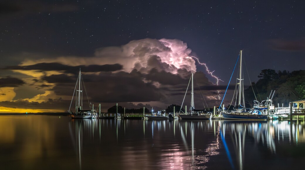 Lightning bursting out from cloud with coastal landscape