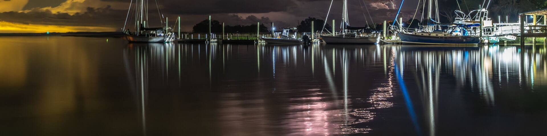 Lightning bursting out from cloud with coastal landscape