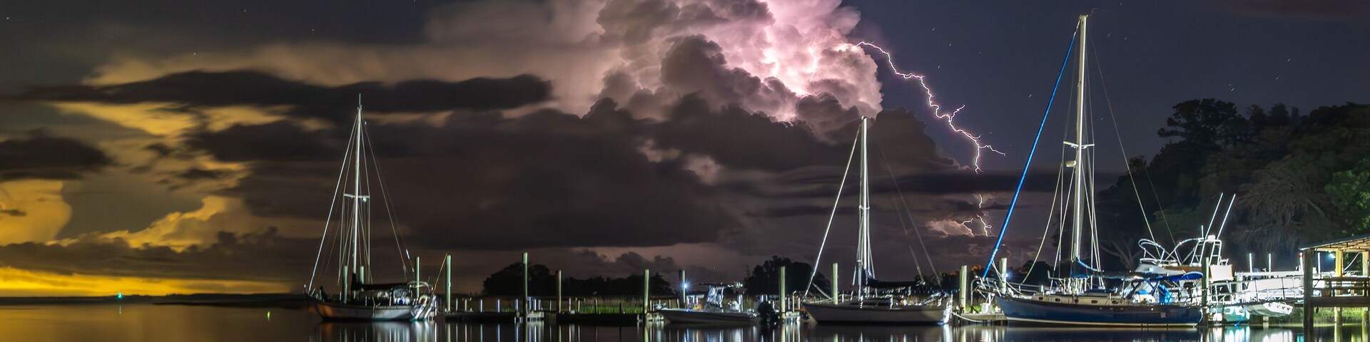 Lightning bursting out from cloud with coastal landscape