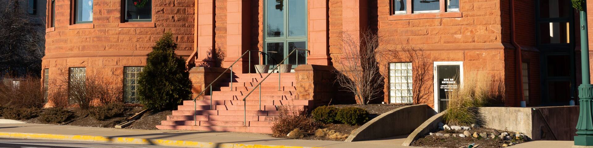 A red brick building with a dome and columns, labeled "Public Library."