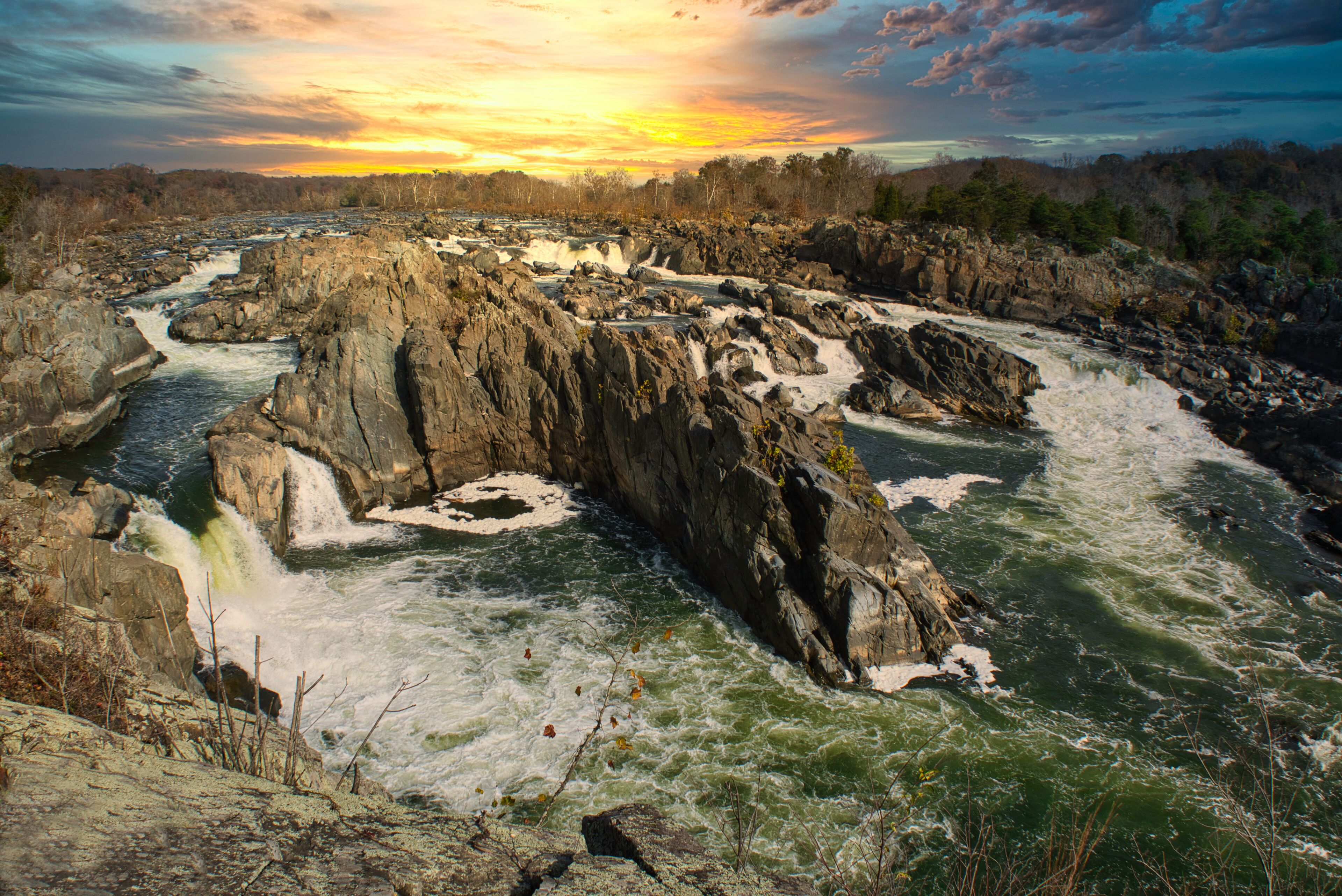 Potomac River waterfalls panorama in Great Falls state park in Virginia, USA. Great Falls state park at sunset in autumn with birds of prey circling above the rapids.