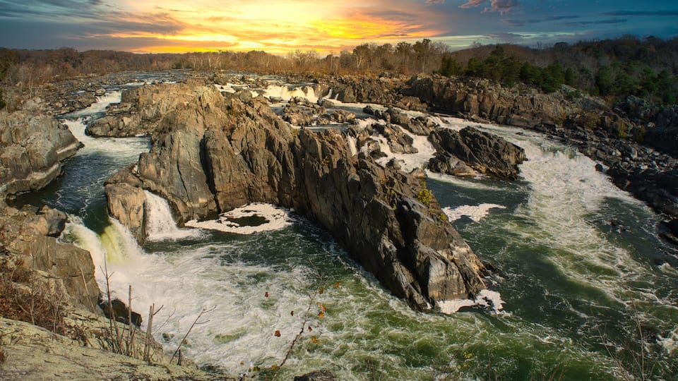 Potomac River waterfalls panorama in Great Falls state park in Virginia, USA. Great Falls state park at sunset in autumn with birds of prey circling above the rapids.