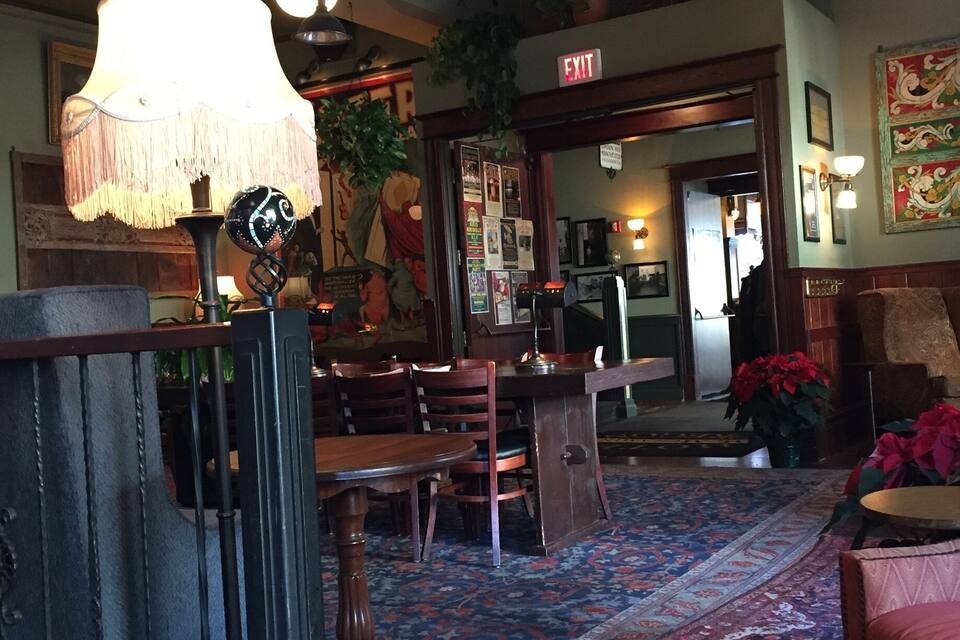 L’intérieur chaleureux du restaurant est agrémenté de meubles en bois, d’un tapis à motifs et de luminaires suspendus.