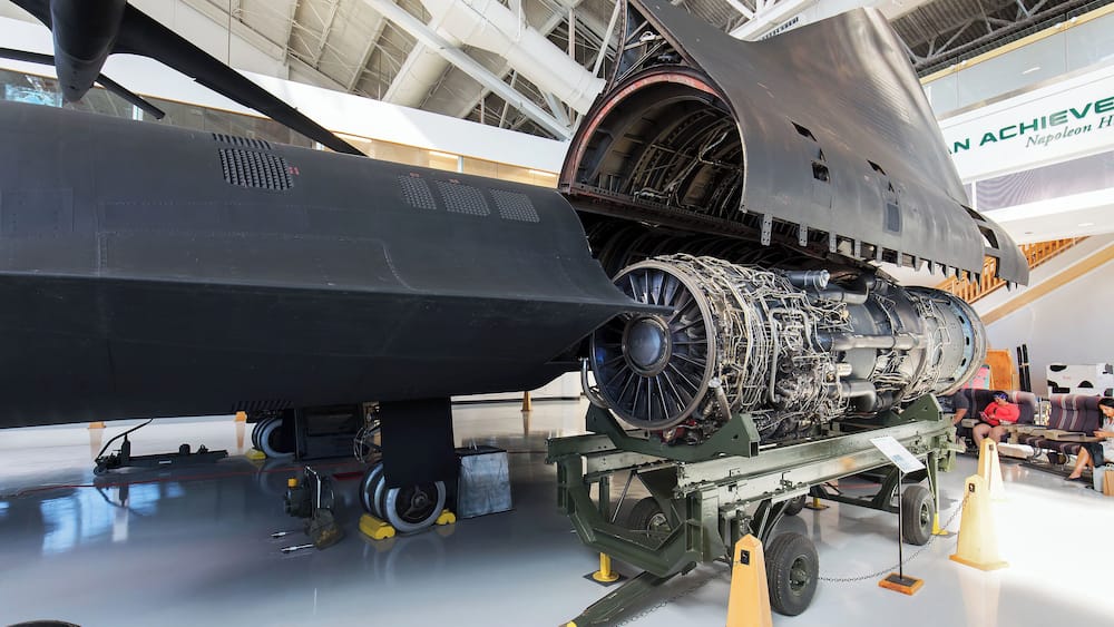 A large aircraft engine mounted on a display stand in a museum.
