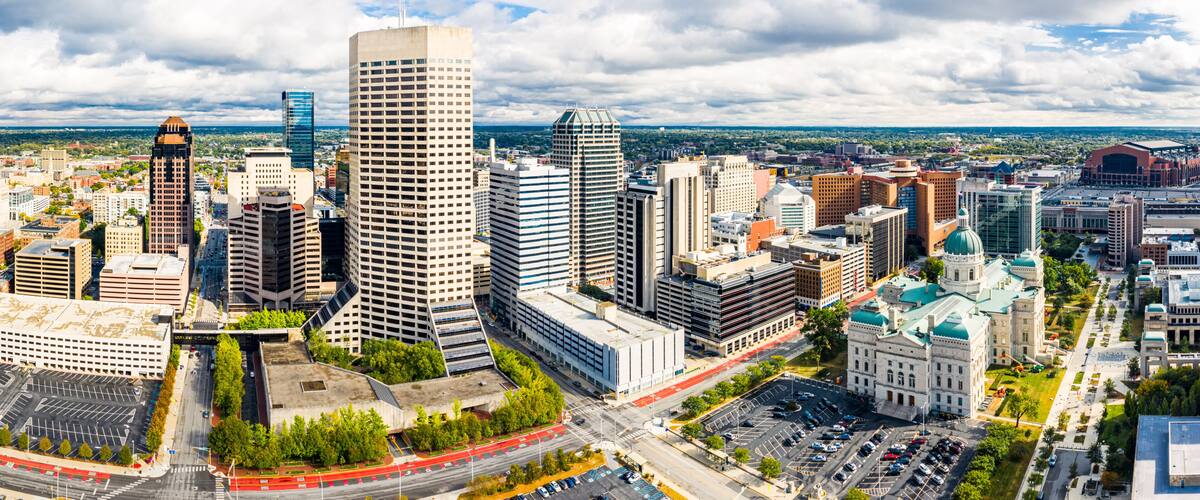 A cityscape with a prominent skyscraper, a dome-shaped building, and a mix of modern and traditional architecture.