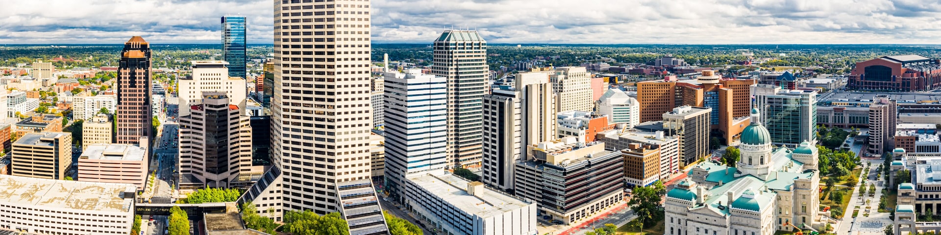A cityscape with a prominent skyscraper, a dome-shaped building, and a mix of modern and traditional architecture.