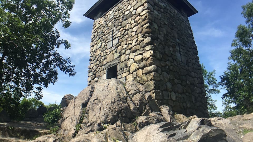 A stone tower with a flat roof on a rocky outcrop.