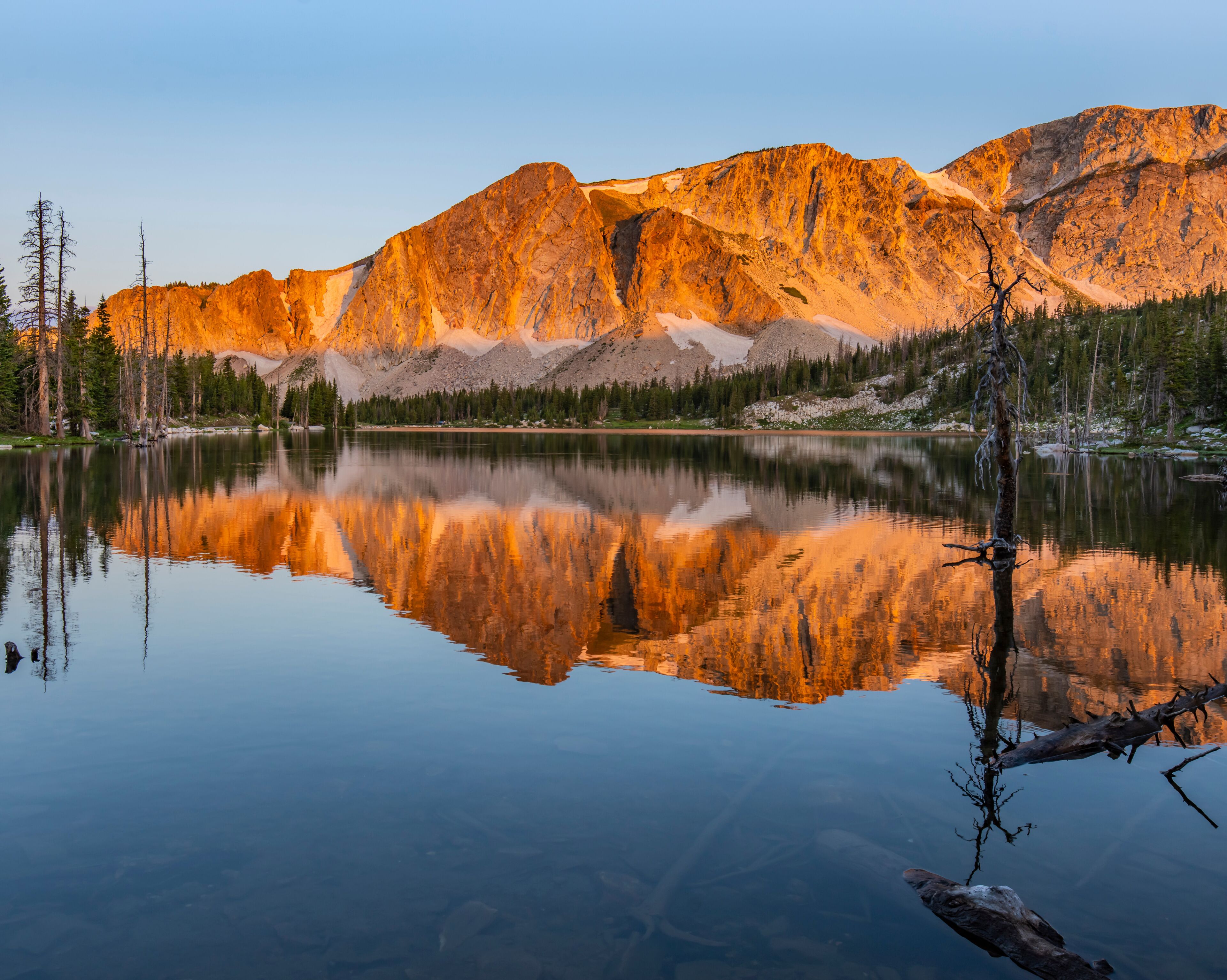 Mirror Lake Reflection - The sunrise lights up the peaks of the Snowy Range Mountains and is reflected in Mirror Lake. Medicine Bow National Forest, Centennial, Wyoming.