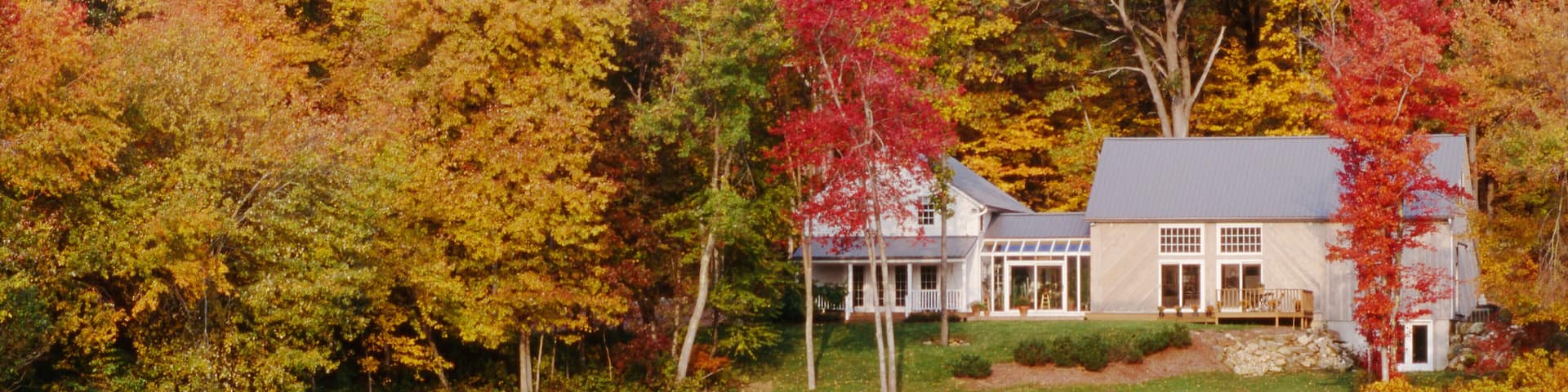 A Connecticut home in autumn surrounded by colorful foliage.