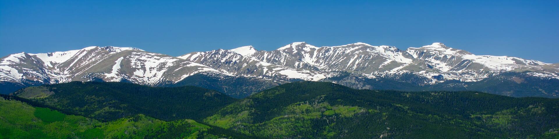 A mountain range with snow-capped peaks and lush green valleys.