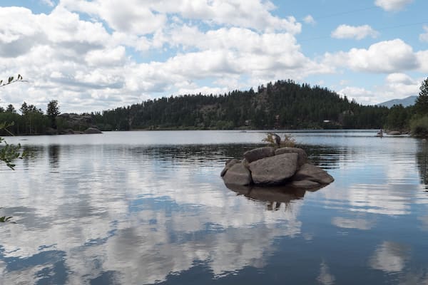 Clouds reflecting of the water of the beautiful private Lake Hiawatha in Red Feather Lakes, Colorado.