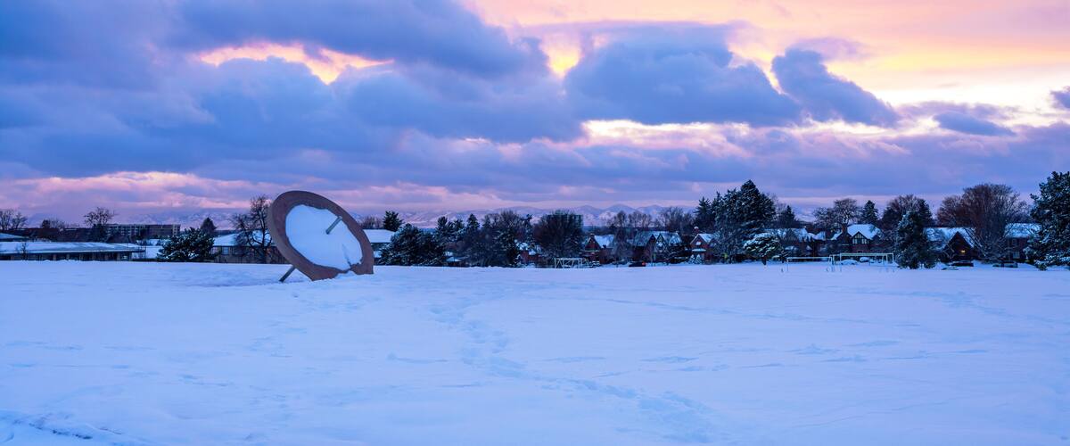 Winter sunset scene at Cranmer Park in the Hilltop neighborhood in Denver, Colorado with its iconic Sundial and view of the mountain range in the distance.