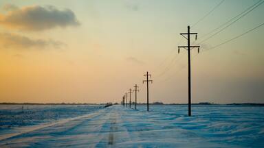 Telephone poles line an empty snow-covered dirt road Mount Pleasant, Iowa on January 4th, 2008.