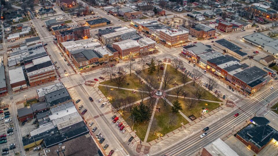 An aerial view of a city with a central square, surrounding streets, and buildings.