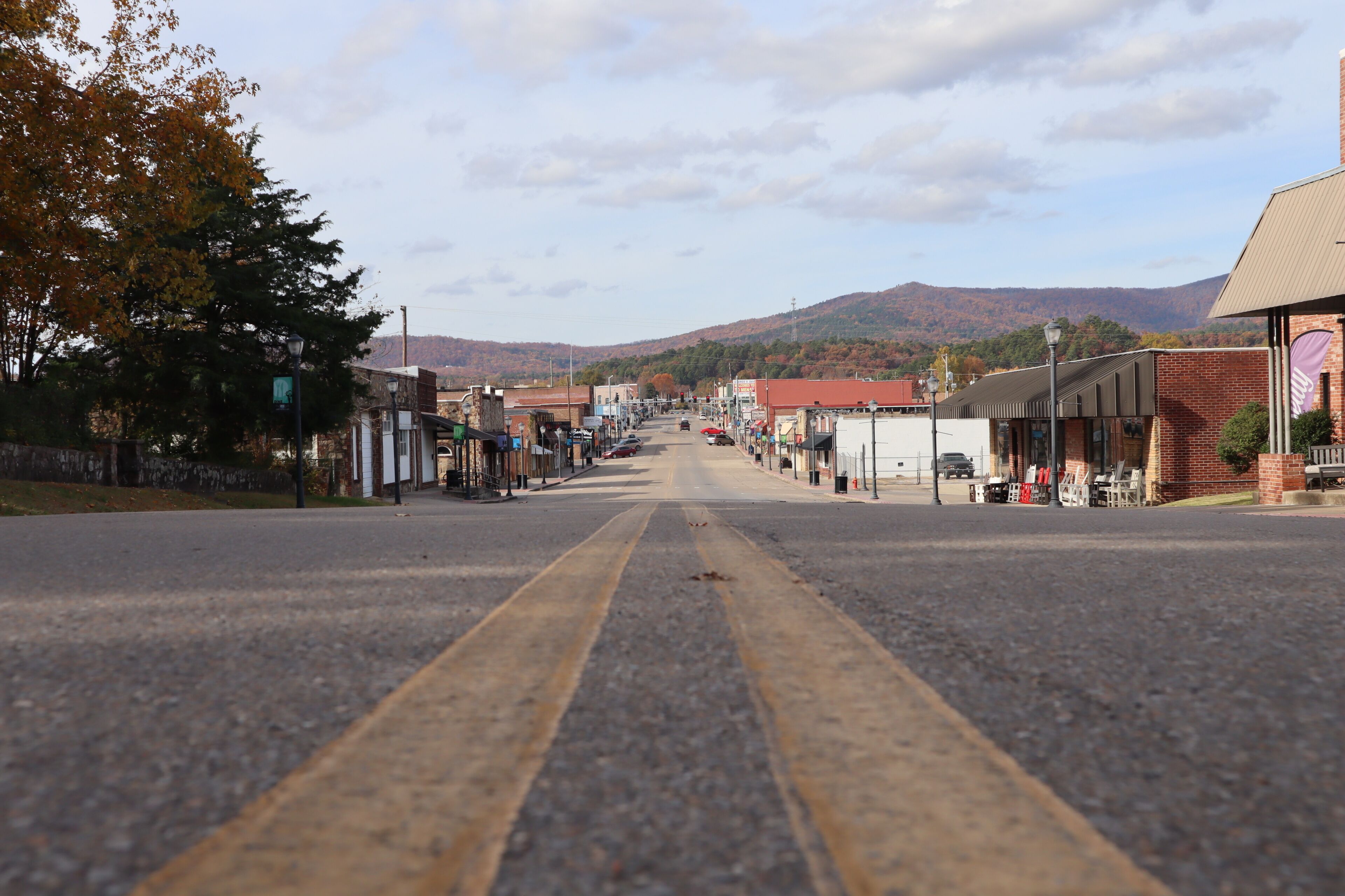 A street with buildings, a mountain in the background, and a clear sky.