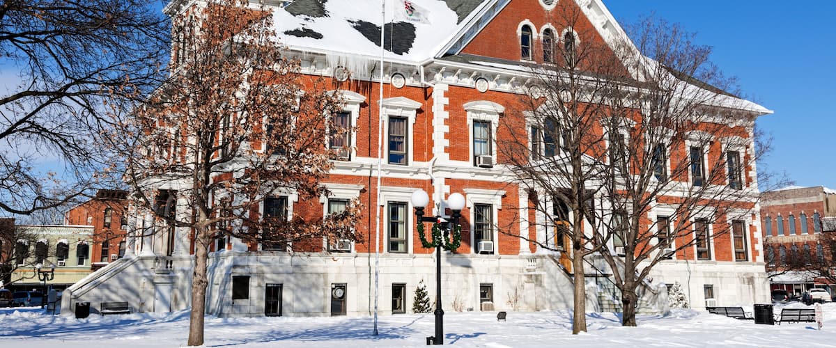 A historic building with a clock tower and an American flag.