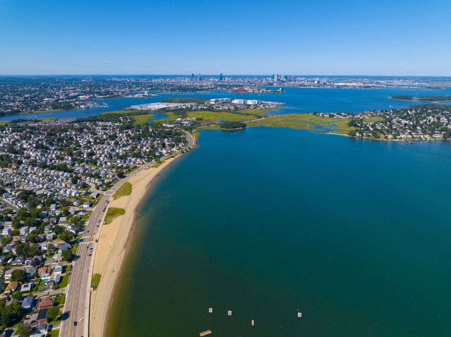 Wollaston Beach aerial view and Quincy Shore Drive next to the beach in Quincy Bay with Boston modern skyline at the background in Wollaston, city of Quincy, Massachusetts MA, USA.