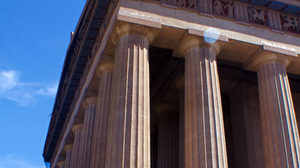 A classical building with large columns and a detailed frieze.