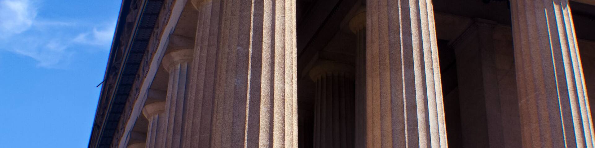 A classical building with large columns and a detailed frieze.