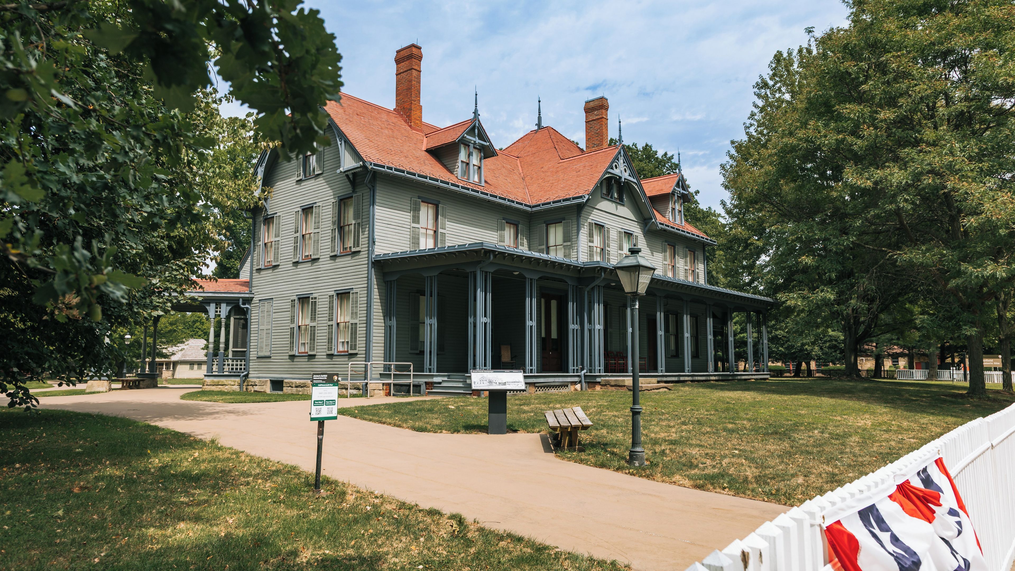 A large, historic house with a red-tiled roof and a porch.