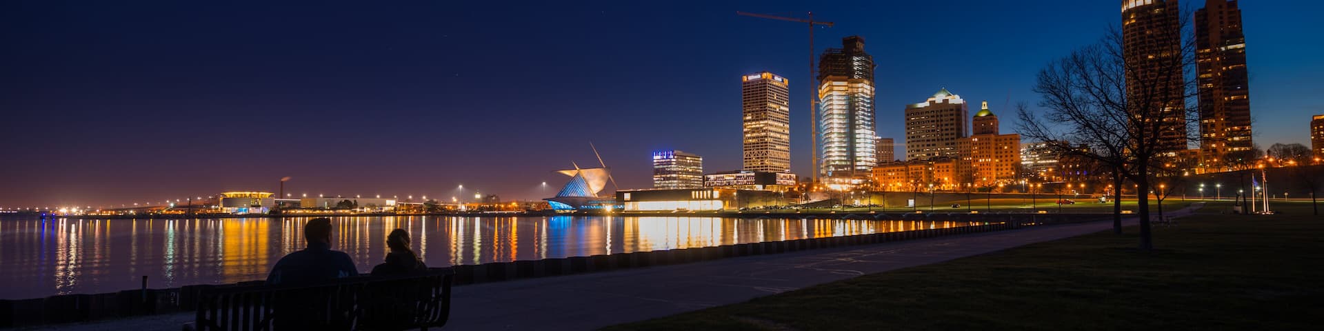 Couple sitting on a bench looking at City of Milwaukee Wisconsin at Night