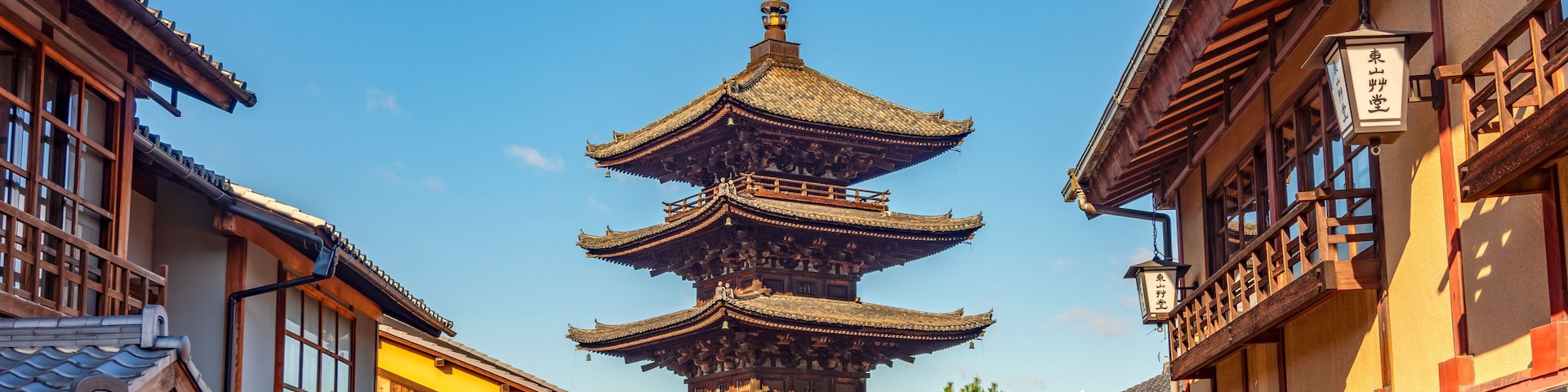 A traditional Japanese pagoda with multiple tiers, surrounded by wooden buildings with tiled roofs.