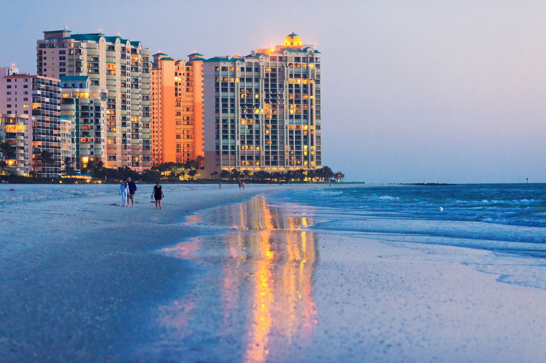 "marco island beach ocean front building shoot at dusk, big reflection on wet sand."