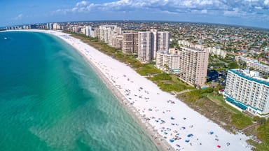 Une ville côtière dotée d’une longue plage de sable blanc, d’eaux turquoise cristallines et d’immeubles de grande hauteur qui bordent la côte.