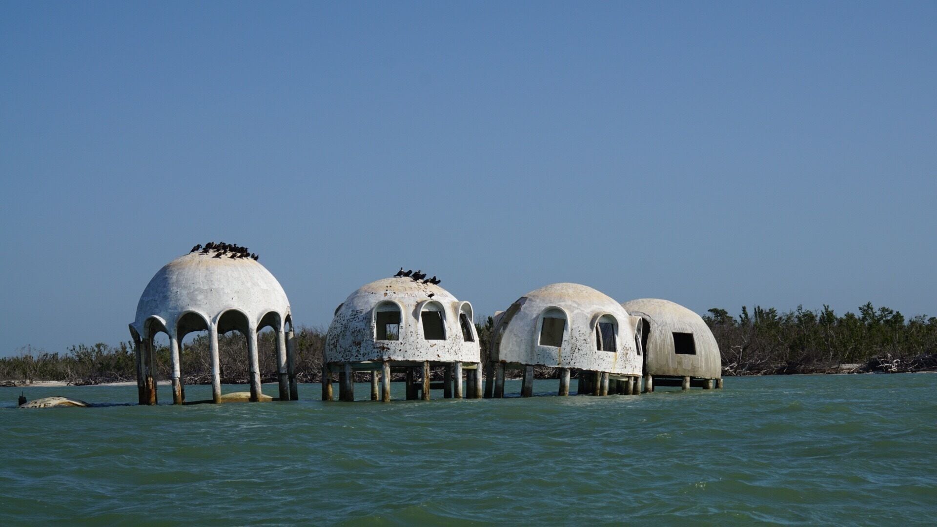 The Cape Romano Dome House is an abandoned modern house located on Caxambas Island, south of Marco Island in Cape Romano in the Ten Thousand Islands of Collier County, Florida. It was constructed in 1980 by retired businessman Bob Lee, abandoned in 1992, sold in 2005 to John Tosto. Though originally constructed on and intended to sit on land, shoreline erosion, is now approximately 180 feet offshore.