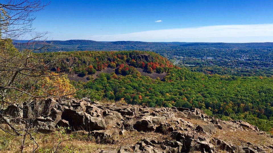 A mountainous landscape with rocky outcrops and autumn-colored trees.