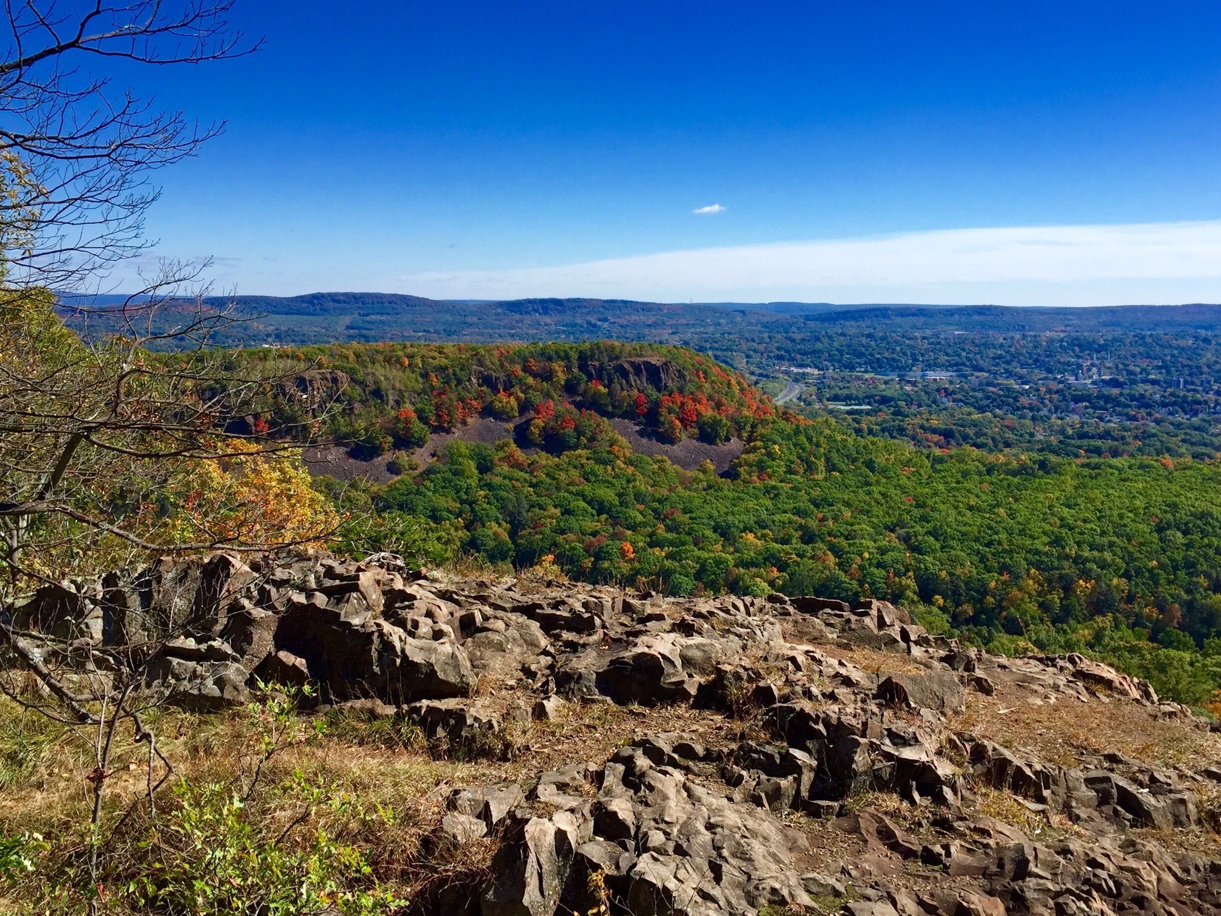 A mountainous landscape with rocky outcrops and autumn-colored trees.