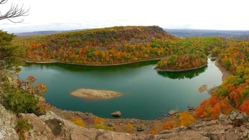 A lake surrounded by autumn-colored trees and rocky terrain.