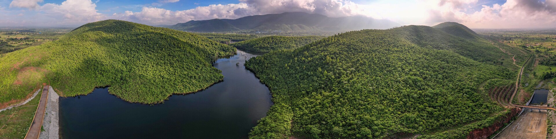 Aerial panoramic landscape with green hills, river and forest