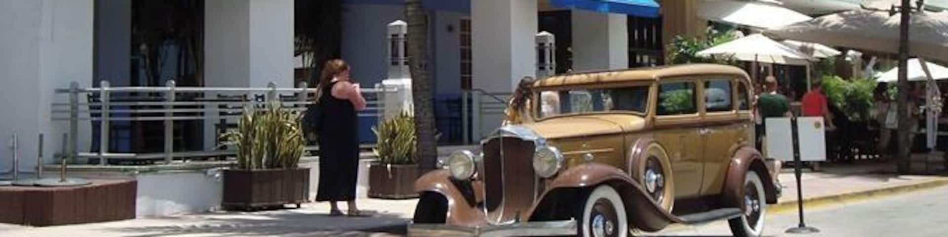 A vintage car parked in front of the PARIS HOTEL.