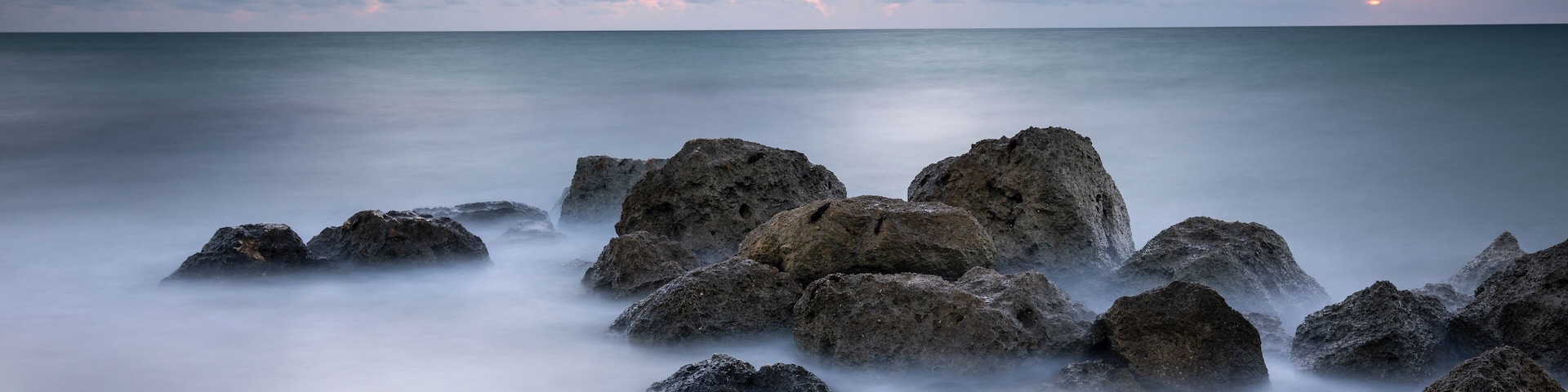 Uma costa rochosa sob um céu nublado.