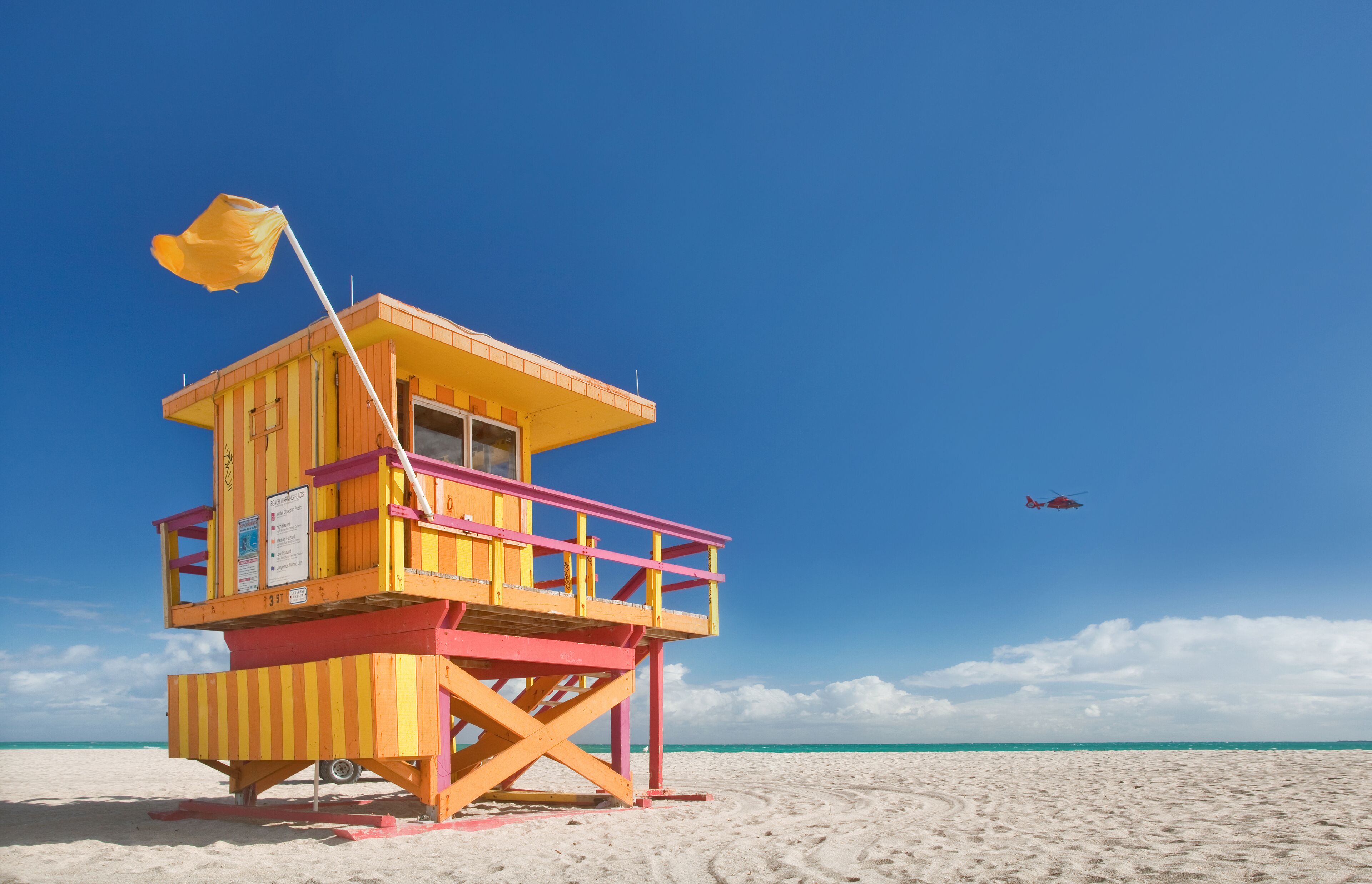 Miami Beach Florida, lifeguard house in a typical colorful Art Deco style on a bright  sunny summer day, with blue sky and Atlantic Ocean in the background. World famous  travel location