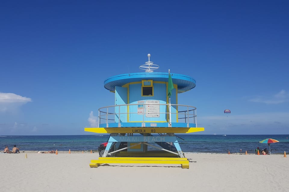 A lifeguard tower at Miami Beach with a clear blue sky and ocean in the background.
