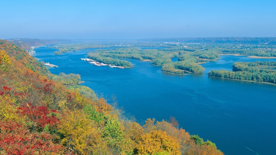 A river with several locks and a bridge in the distance.