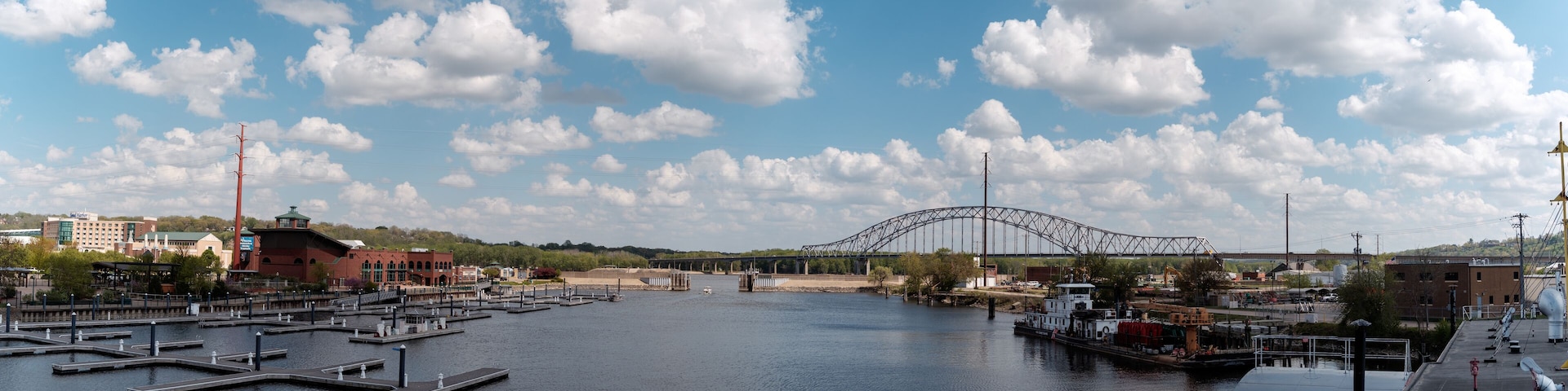 A river with docks, a bridge, and buildings in the background.