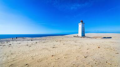 The iconic lighthouse Rubjerg Knude Fyr in the dunes of northern Denmark on a summer day