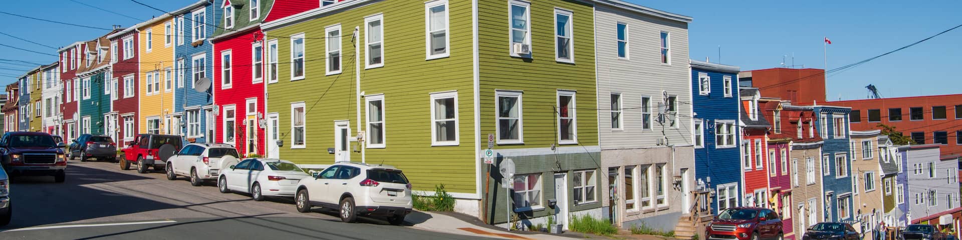 The vibrant, rainbow-colored row houses of St. John's, known as Jelly Bean Row, extend beyond a single street. They are a prominent feature of the densely built downtown area, stretching down to the h
