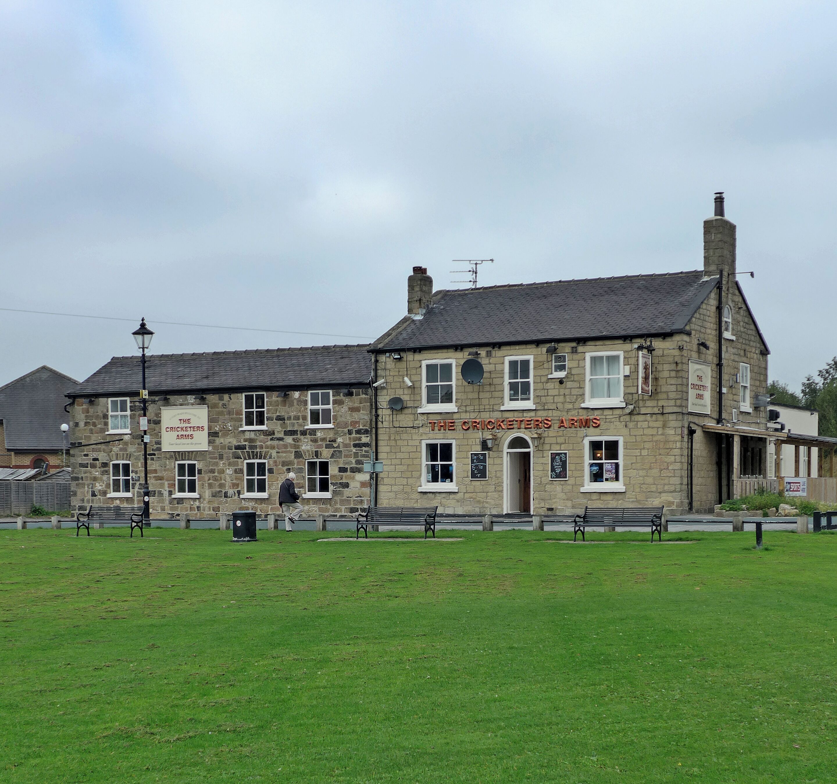 A stone building with a sign reading "The Cricketers Arms".