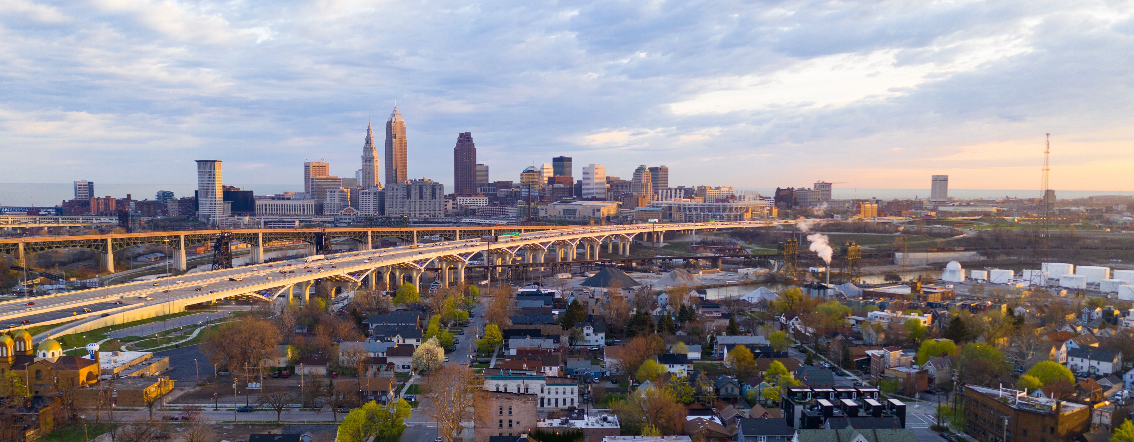 A city skyline with a prominent bridge and industrial area.