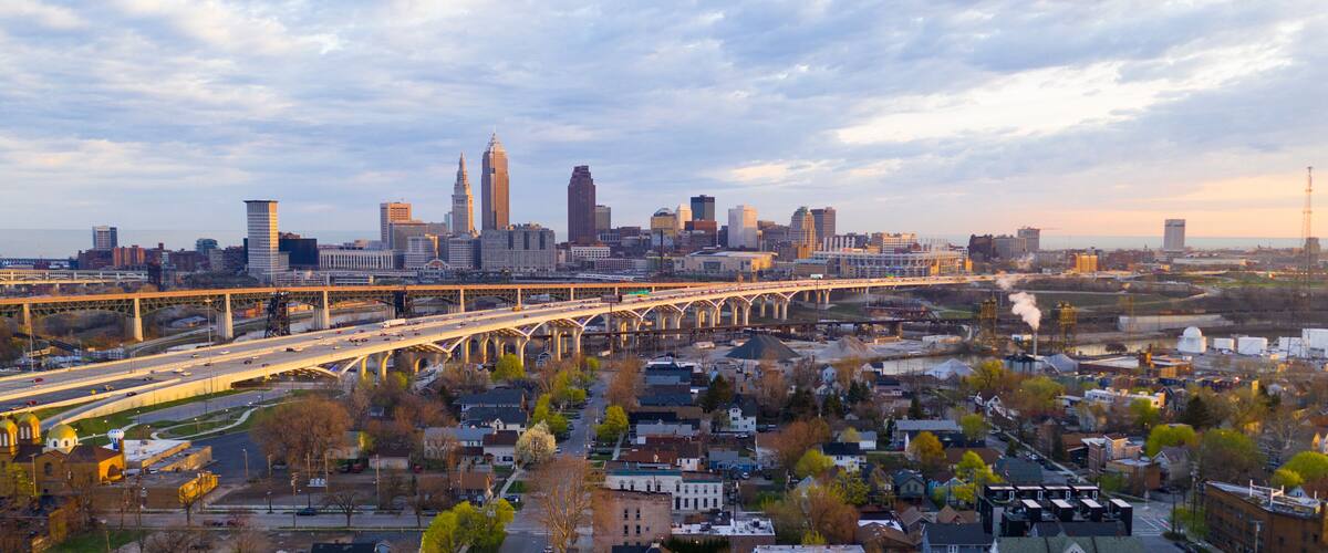 A city skyline with a prominent bridge and industrial area.